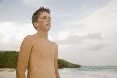 Boy standing on beach. Photographe : mark edward atkinson