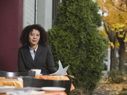 Businesswoman sitting at outdoor cafe.