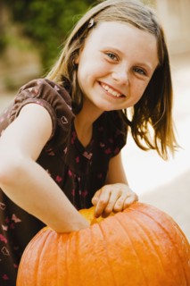 Girl scooping out pumpkin. Photographe : Sarah M. Golonka
