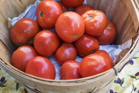 Tomatoes in a basket at a fruit stand. Photographe : fotog