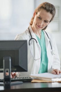 Female doctor looking at computer monitor.
