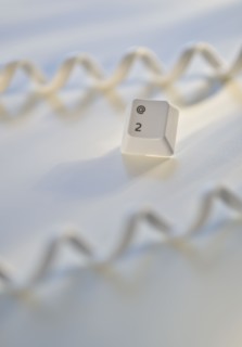Close up of telephone cord and computer key.