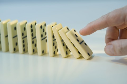 Man pushing row of dominoes.