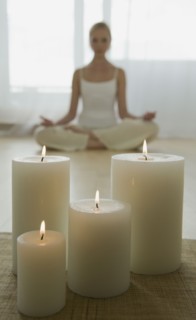 Woman meditating with candles.