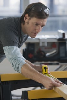 Construction worker measuring board.