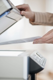 Woman using photocopier, close-up.