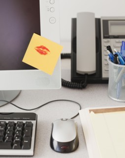 Adhesive note with lipstick kiss on computer monitor. Photographe : Jamie Grill