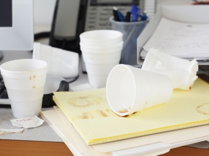 Messy office desk with empty disposable cups. Photographe : Jamie Grill