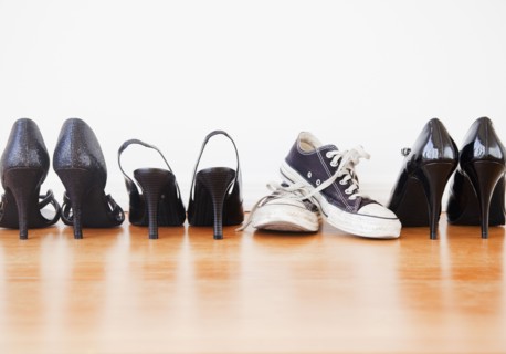 Canvas shoe in row of elegant high heel shoes. Photographe : Jamie Grill