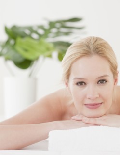 Young woman lying on front and waiting for massage, portrait. Photographe : Jamie Grill