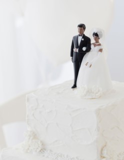 Bride and groom cake toppers on wedding cake. Photographe : Jamie Grill