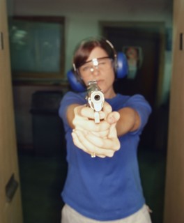 Young woman holding gun. Photographe : Stewart Cohen