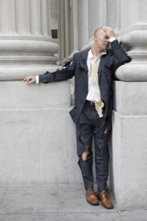 Businessman wearing torn clothing outside office building, San Francisco, California, USA.