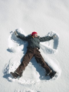 Woman making snow angel. Photographe : John Kelly