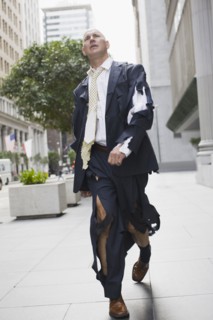Businessman wearing torn clothing, walking in street, San Francisco, California, USA. Photographe :