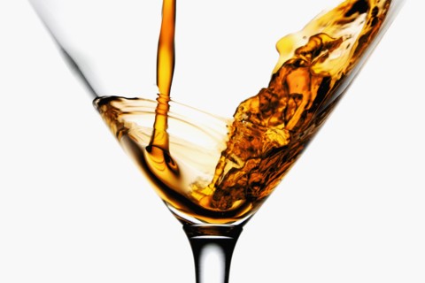 Drink being poured into wineglass, close-up. Photographe : Joe Clark