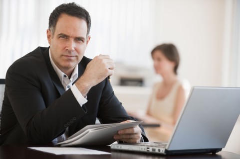 Portrait of successful mature businessman working in office.