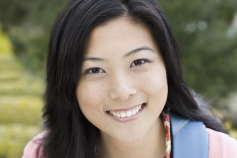 Portrait of young woman smiling, outdoors. Photographe : PT Images
