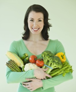 Woman holding various vegetables.