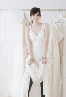 Portrait of young woman wearing wedding dress in shop. Photographe : Jamie Grill