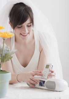 Bride holding speakers of stereo, studio shot. Photographe : Jamie Grill
