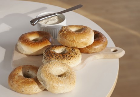 Bagels and creme cheese on table.