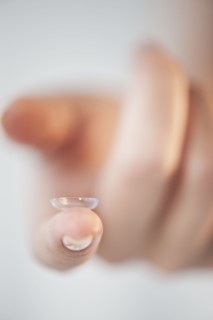 Close-up of contact lens on woman's finger.