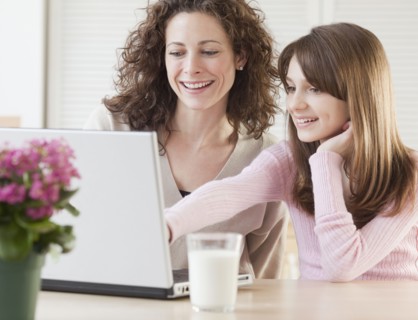 Mother and daughter (10-12 years) surfing in internet. Photographe : Jamie Grill