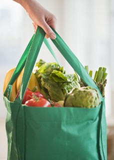 Woman holding grocery bag, close-up.