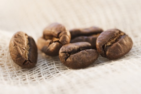 Roast coffee beans on fabric, studio shot.