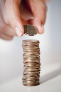 Close-up of woman's hand stacking coins.