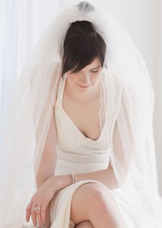 Pensive bride in wedding dress, studio shot. Photographe : Jamie Grill
