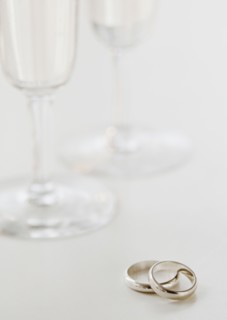 Two wedding rings by wineglasses. Photographe : Jamie Grill