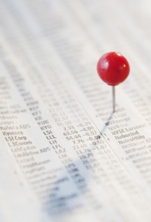 Close-up of pin on stock market newspaper. Photographe : Jamie Grill