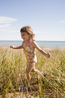 Beaver Island, Girl running in grass on beach, Beaver Island, Michigan, USA. Photographe : Shawn