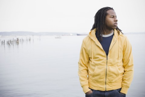 Teenage boy (16-17) with dreadlocks, standing at waterfront, San Francisco, California, USA.