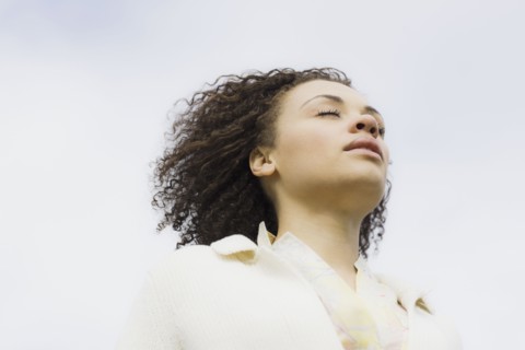 Young woman with eyes closed, outdoors. Photographe : PT Images