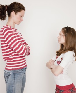 Mother and daughter (10-12 years) having argument, standing face to face. Photographe : Jamie Grill