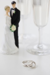 Wedding rings by bride and groom cake toppers and wineglasses. Photographe : Jamie Grill