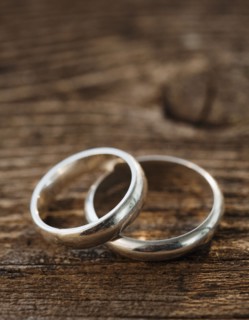 Two wedding rings on wooden table. Photographe : Jamie Grill