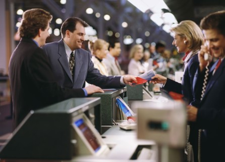 Businessman buying ticket at the airport. Photographe : Stewart Cohen