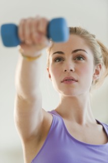 Young woman weight lifting. Photographe : Daniel Grill