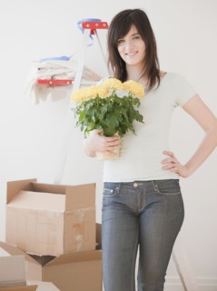 Portrait of young woman redecorating new house. Photographe : Jamie Grill