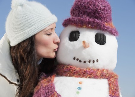 Woman kissing snowman.