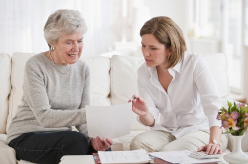 Mature woman giving financial advice to senior woman.