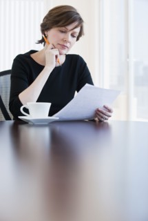 Mature businesswoman reading document.