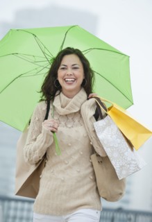 A woman with shopping bags in the rain.