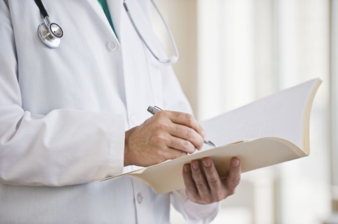 A doctor writing in a file