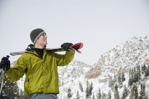 A downhill skier carrying skis