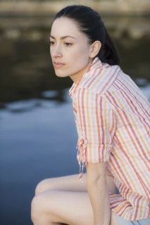 A woman sitting by water